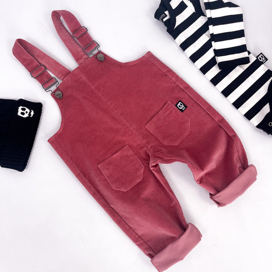 Kids corduroy dungarees in dusky rose pink with clip fastenings, front and back pockets