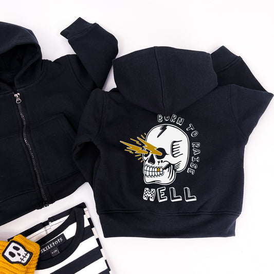 Kids black hoodie with "born to raise hell" printed on and a design of a skull shooting lightning bolts from its eye sockets