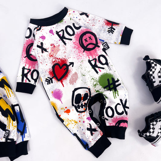 Footless baby romper with colourful graffiti print skulls, hearts, lightning bolts and paint splatter