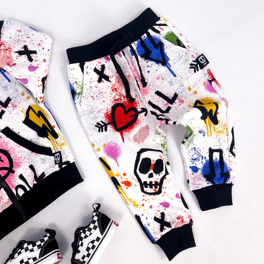 Kids white joggers with colourful graffiti print skulls, hearts, lightning bolts and paint splatter