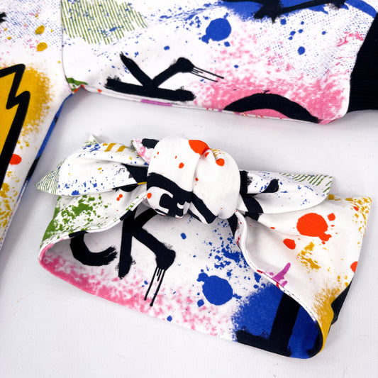 Stretchy headband with colourful paint splatter and graffiti print