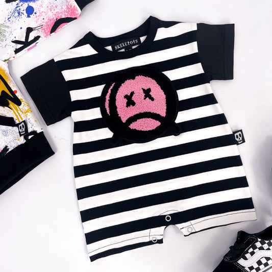 Black and white striped baby romper with sad face patch