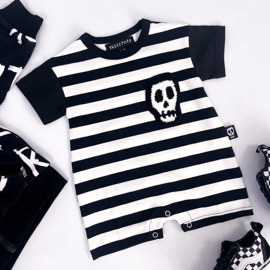 Black and white striped baby romper with skull patch