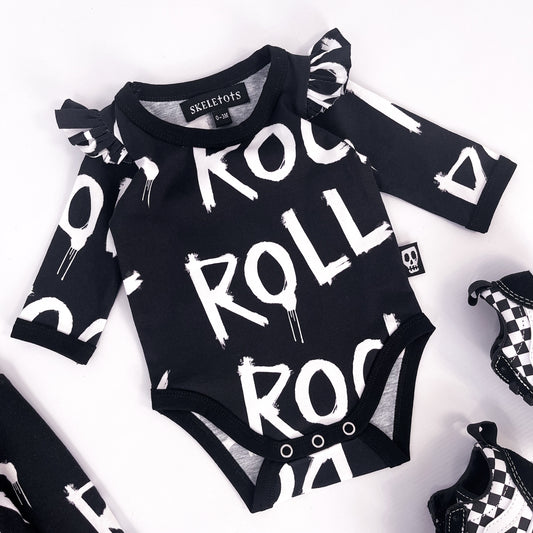 Baby's bodysuit with frilled shoulder details, pressed stud fasteners and the words "rock" and "roll" printed on