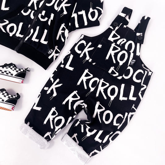 Kids black dungarees with words "rock" and "roll" printed on it repeatedly