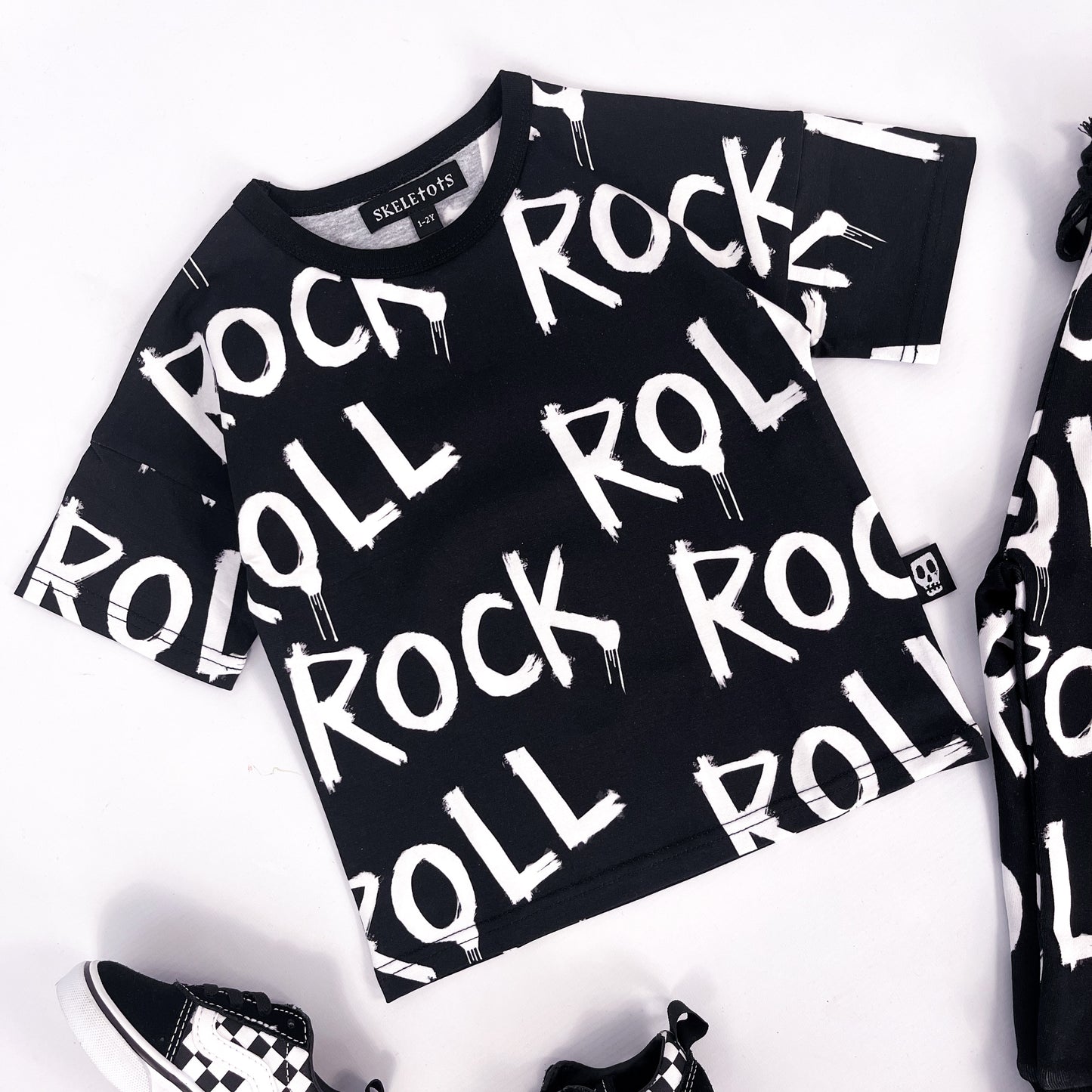 Kids black tee shirt with words "rock" and "roll" printed on it repeatedly