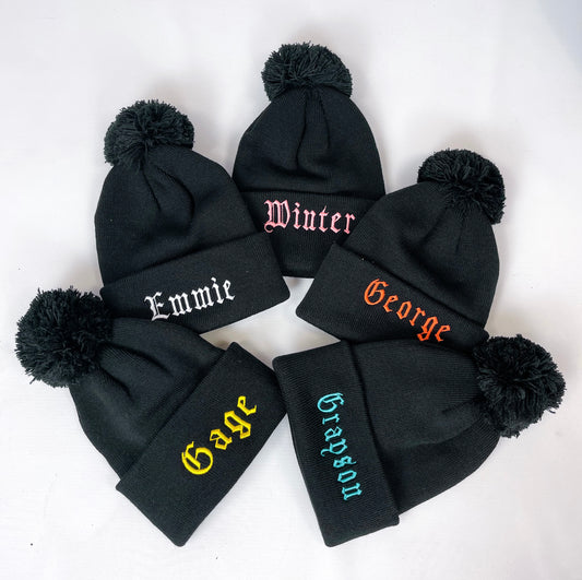 Personalised kids bobble hats, black with custom name printing in gothic script